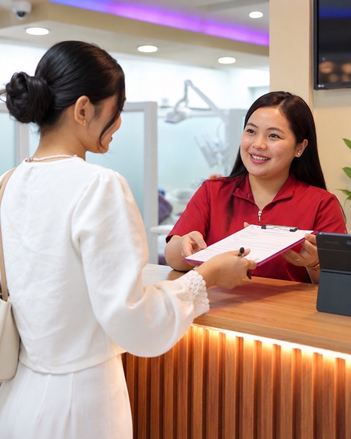 A patient being welcomed at the Home of Dental Aesthetics front desk